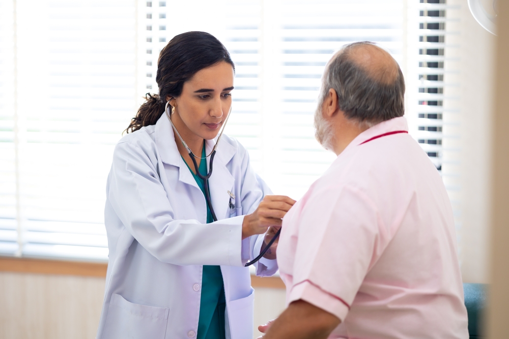 Una doctora examina a un paciente con sobrepeso